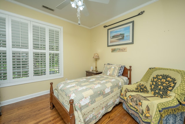 bedroom featuring hardwood / wood-style floors, ceiling fan, and ornamental molding