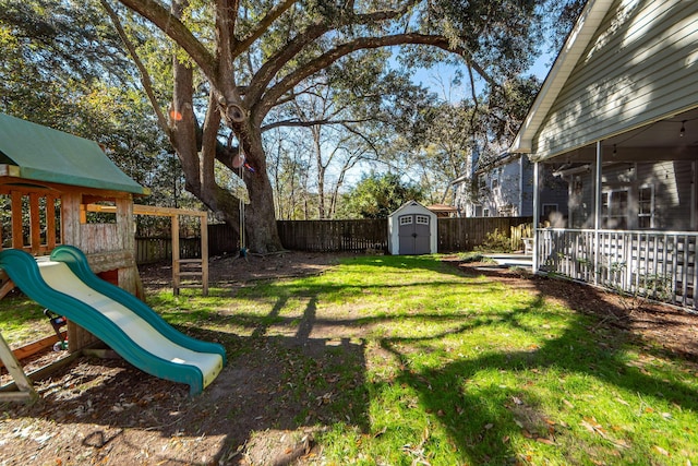 view of yard featuring a storage unit and a playground