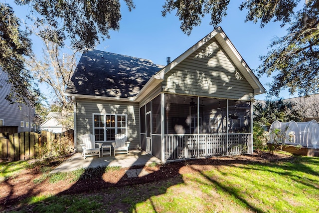 rear view of property with a lawn, a patio area, and a sunroom