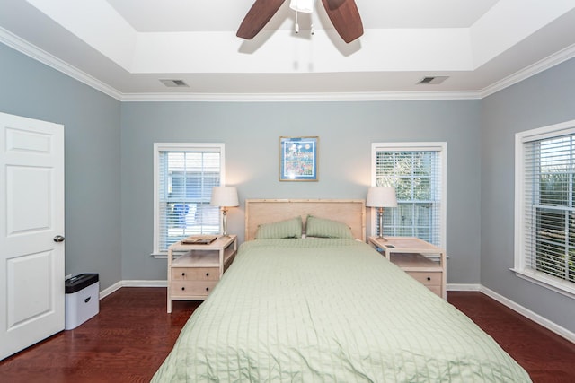 bedroom with a raised ceiling, ceiling fan, crown molding, and dark hardwood / wood-style floors