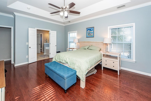 bedroom with ceiling fan, ornamental molding, dark wood-type flooring, and a tray ceiling