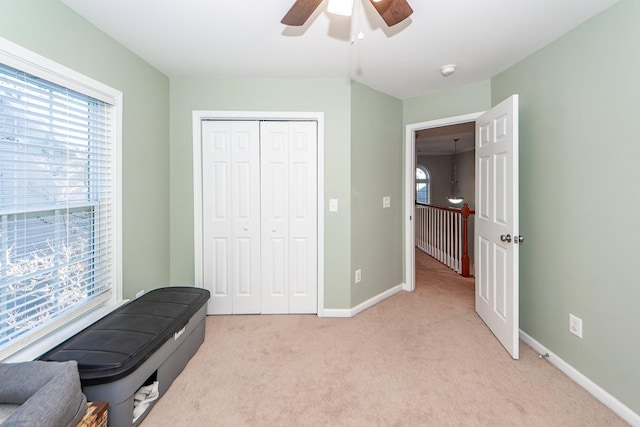 interior space with ceiling fan and light carpet