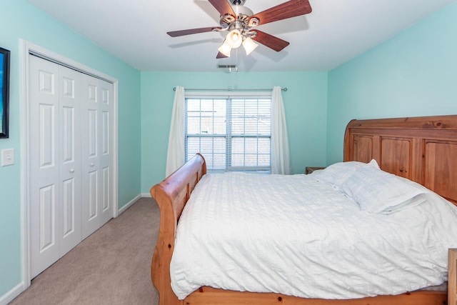 bedroom featuring ceiling fan, light carpet, and a closet