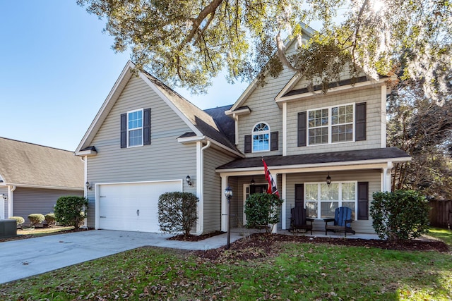 front of property featuring covered porch, a garage, and a front lawn