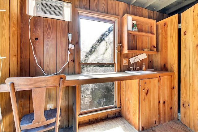 interior space featuring wood walls, light wood-type flooring, sink, and a wall mounted AC