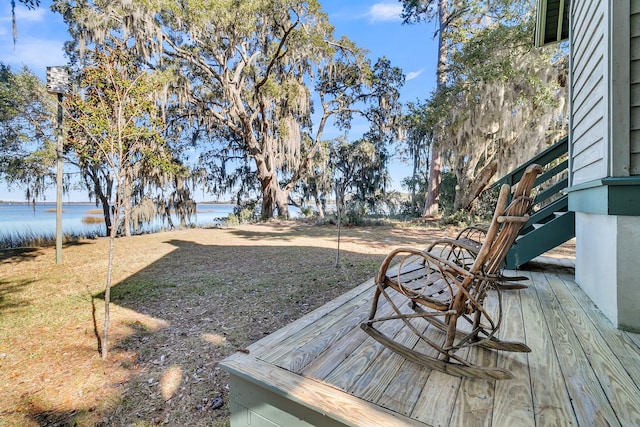 view of yard with a deck with water view