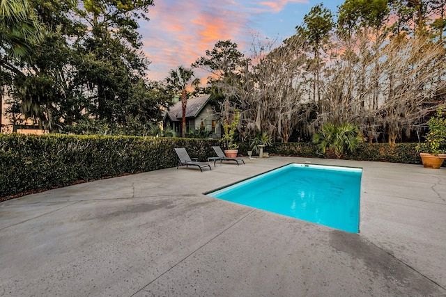 pool at dusk with a patio