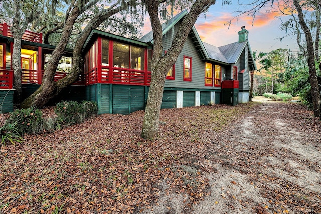 property exterior at dusk with a sunroom