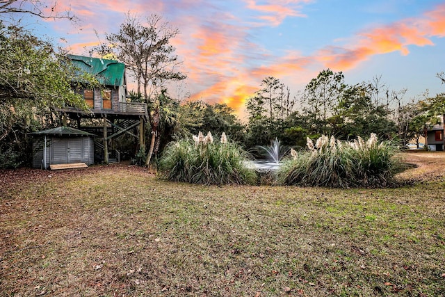 yard at dusk featuring a deck