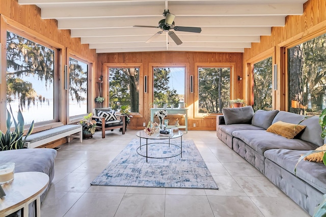 sunroom featuring beamed ceiling, ceiling fan, and a healthy amount of sunlight