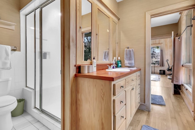 bathroom with tile patterned flooring, vanity, an enclosed shower, and toilet