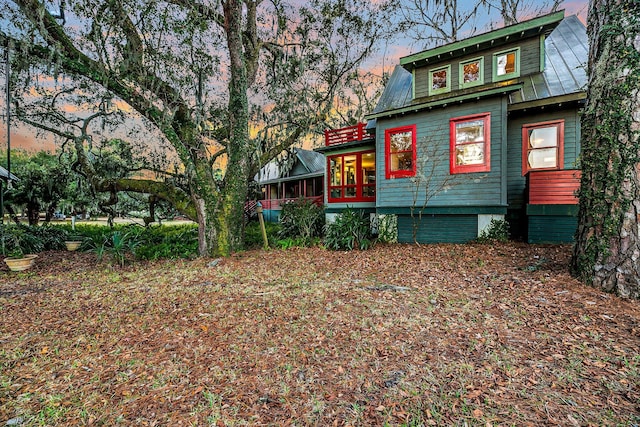 back house at dusk featuring a sunroom