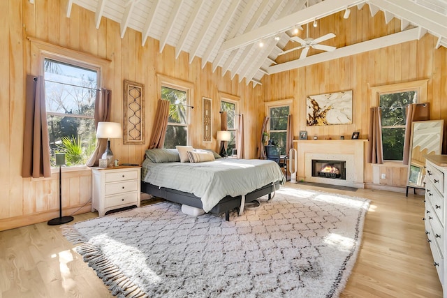 bedroom with beamed ceiling, light hardwood / wood-style floors, wooden ceiling, and high vaulted ceiling