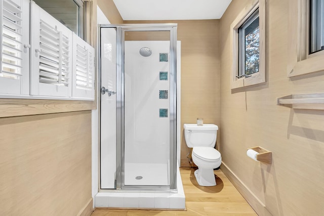 bathroom featuring toilet, wood-type flooring, and walk in shower