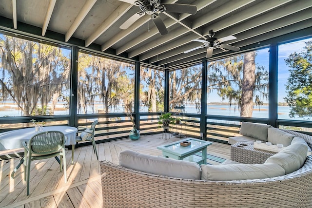 sunroom / solarium with ceiling fan and a water view