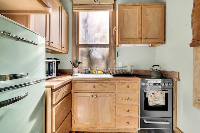 kitchen featuring light brown cabinets, sink, stainless steel appliances, and wooden counters