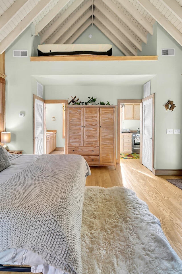 bedroom with light hardwood / wood-style floors, wooden ceiling, beam ceiling, and high vaulted ceiling