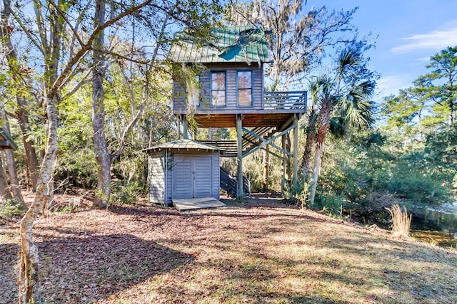 rear view of property featuring a storage shed