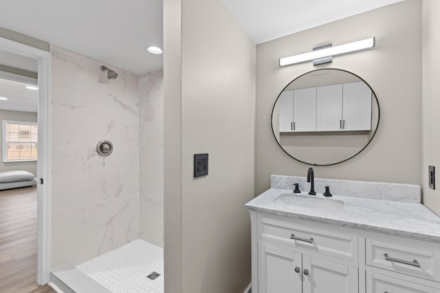 full bathroom featuring a stall shower, wood finished floors, and vanity