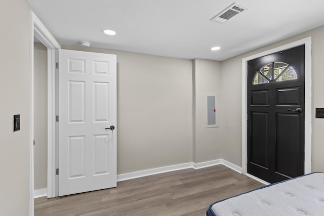 foyer featuring baseboards, visible vents, wood finished floors, and recessed lighting