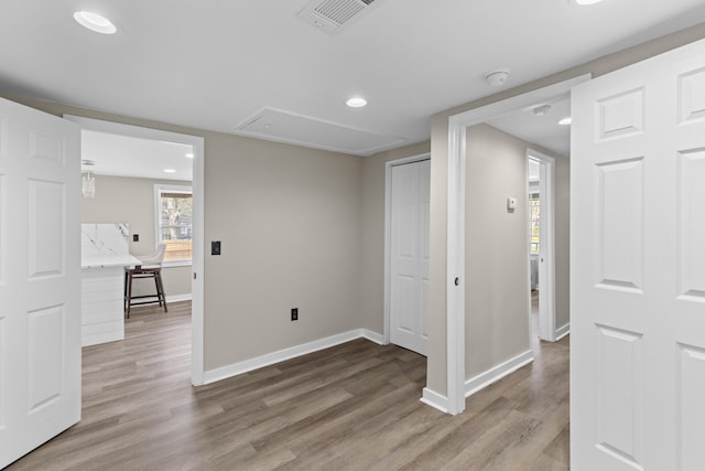 interior space with recessed lighting, wood finished floors, visible vents, baseboards, and attic access