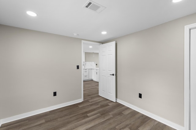 spare room with recessed lighting, visible vents, dark wood finished floors, and baseboards