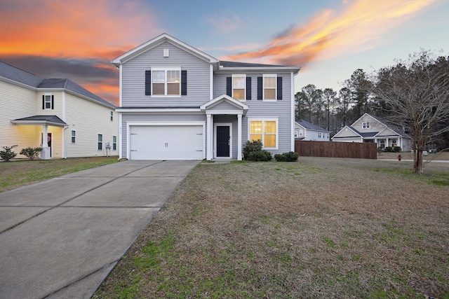 view of front property featuring a garage and a yard