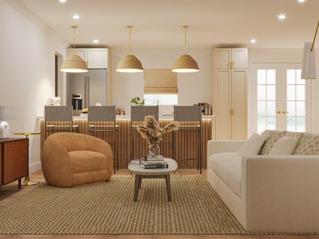 living room featuring light wood-type flooring, french doors, and crown molding