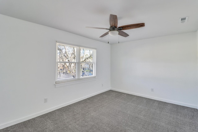 empty room featuring baseboards, visible vents, dark colored carpet, and ceiling fan