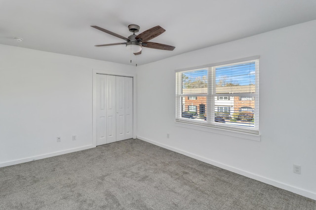 unfurnished bedroom featuring carpet flooring, baseboards, a closet, and ceiling fan