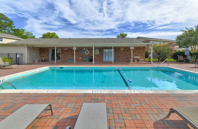 pool with a patio and fence