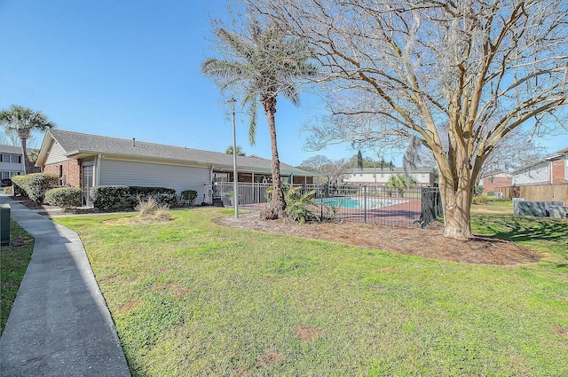 exterior space with brick siding, a fenced in pool, a front lawn, and fence