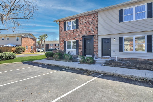 multi unit property featuring brick siding and uncovered parking