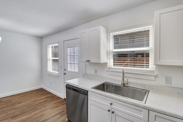 kitchen featuring a sink, stainless steel dishwasher, white cabinets, and light countertops