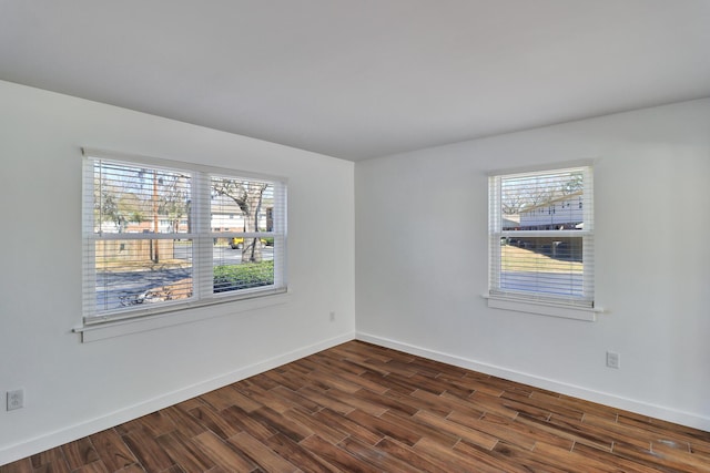 spare room with dark wood finished floors and baseboards