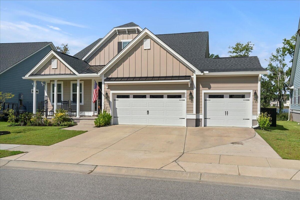 craftsman inspired home with a garage, a front lawn, and a porch