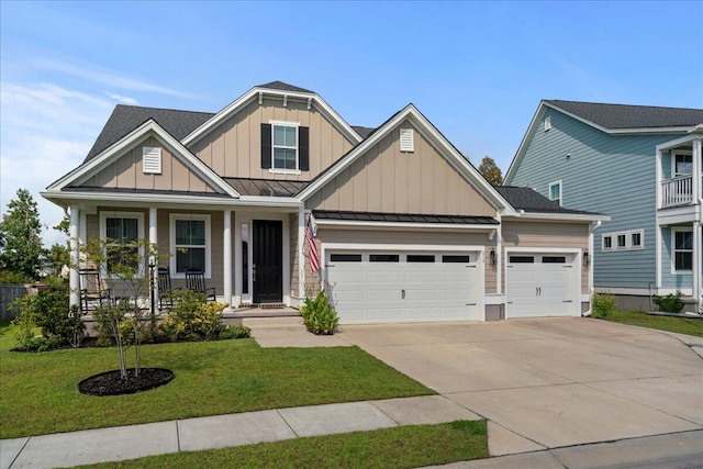 craftsman inspired home featuring a porch, a front lawn, and a garage