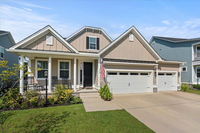 view of front of home featuring a front yard, a garage, and a porch