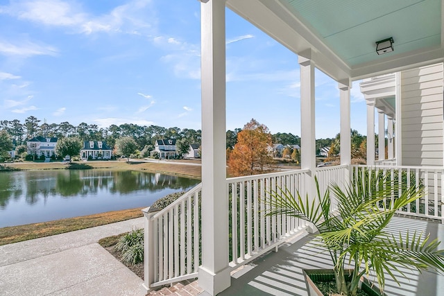 balcony featuring covered porch and a water view