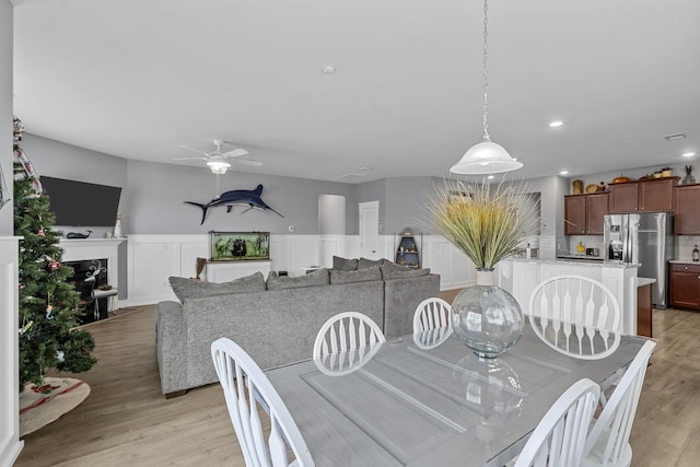 dining room with ceiling fan and light hardwood / wood-style flooring