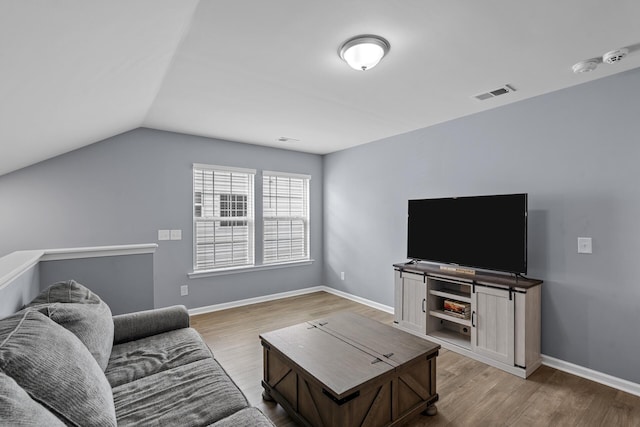 living room with light hardwood / wood-style flooring and lofted ceiling