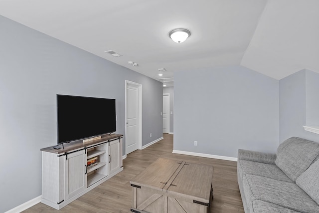 living room featuring light hardwood / wood-style flooring and vaulted ceiling