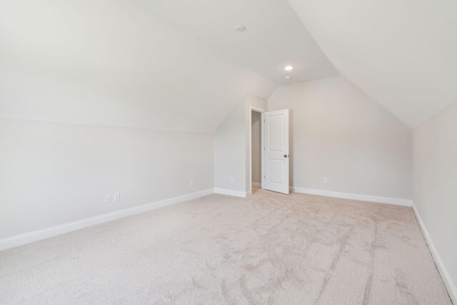 additional living space with light carpet and lofted ceiling