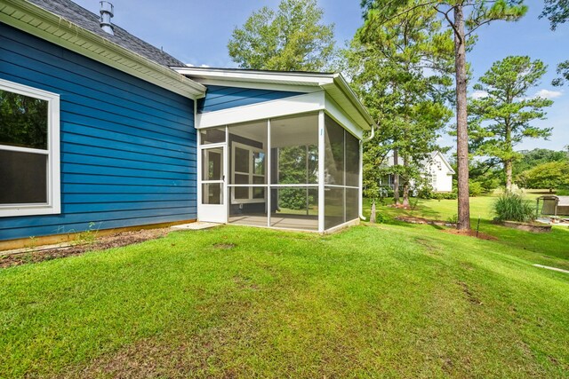 exterior space with a sunroom and a yard