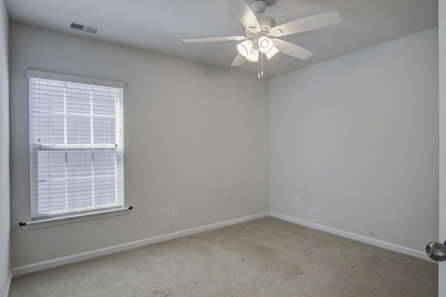 carpeted empty room featuring visible vents, baseboards, and a ceiling fan