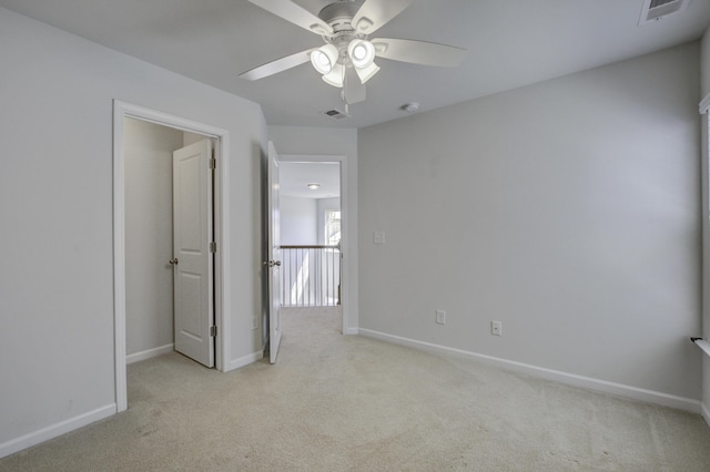 unfurnished bedroom featuring a ceiling fan, baseboards, visible vents, and light carpet