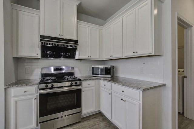 kitchen featuring light stone counters, white cabinetry, appliances with stainless steel finishes, and washer / clothes dryer