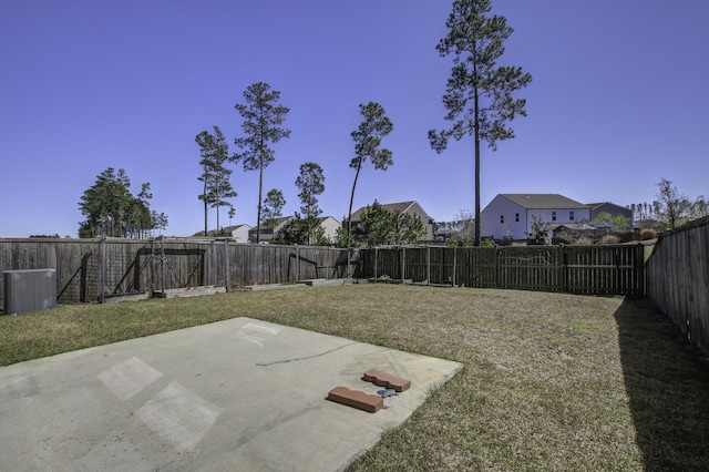 view of yard featuring a patio, central AC unit, a fenced backyard, and a residential view