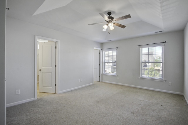 carpeted empty room with visible vents, a ceiling fan, and baseboards