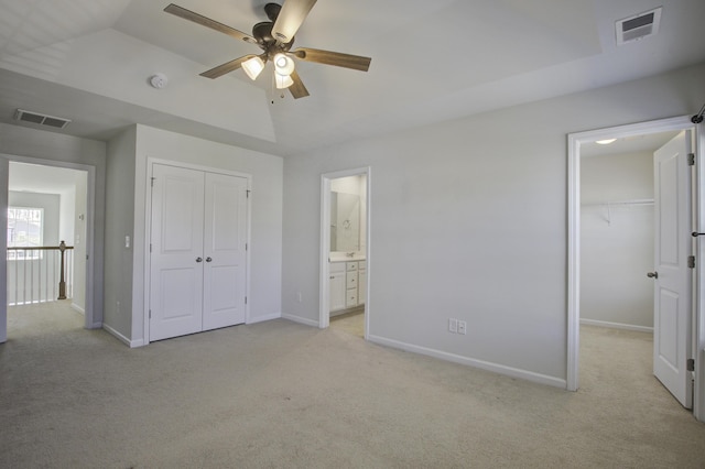 unfurnished bedroom featuring light colored carpet, visible vents, a closet, and baseboards